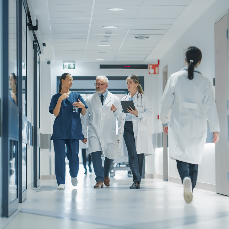 Cheerful,Healthcare,Team,Moving,Through,A,Spacious,Hospital,Corridor,,Preparing